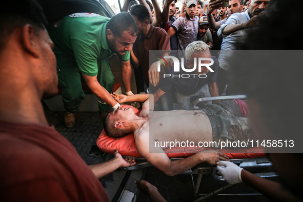 Palestinian medics are transporting an injured person following Israeli bombardment on Deir el-Balah into the Al-Aqsa Martyrs hospital in th...