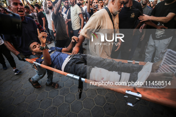 Palestinian medics are transporting an injured person following Israeli bombardment on Deir el-Balah into the Al-Aqsa Martyrs hospital in th...