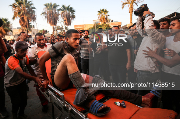 Palestinian medics are transporting an injured person following Israeli bombardment on Deir el-Balah into the Al-Aqsa Martyrs hospital in th...