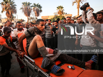 Palestinian medics are transporting an injured person following Israeli bombardment on Deir el-Balah into the Al-Aqsa Martyrs hospital in th...