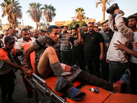 Palestinian medics are transporting an injured person following Israeli bombardment on Deir el-Balah into the Al-Aqsa Martyrs hospital in th...