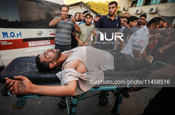 Palestinian medics are transporting an injured person following Israeli bombardment on Deir el-Balah into the Al-Aqsa Martyrs hospital in th...