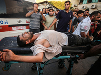 Palestinian medics are transporting an injured person following Israeli bombardment on Deir el-Balah into the Al-Aqsa Martyrs hospital in th...