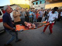 Palestinian medics are transporting an injured person following Israeli bombardment on Deir el-Balah into the Al-Aqsa Martyrs hospital in th...