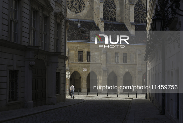 A man walks to work past the Minorite Church in central Vienna early in the morning. Austria, Wednesday, August 7, 2024. 