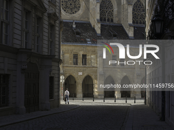 A man walks to work past the Minorite Church in central Vienna early in the morning. Austria, Wednesday, August 7, 2024. (