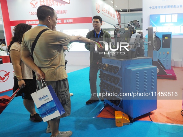 Visitors are visiting an ''Intelligent ultra-thin pipe press'' at the 2024 Beijing International Coal Mining Technology and Equipment Exhibi...