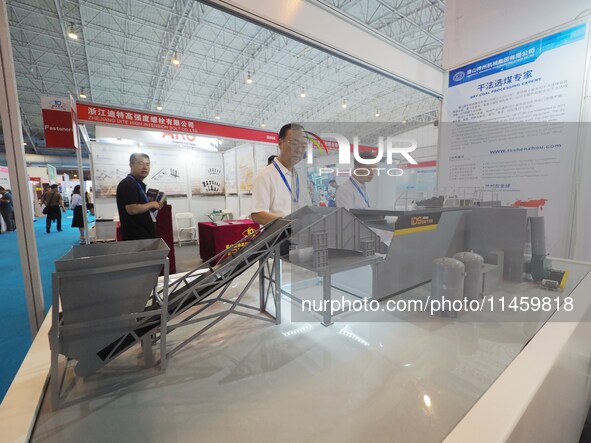 Visitors are viewing a model of the ''intelligent dry coal separator'' at the 2024 Beijing International Coal Mining Technology and Equipmen...