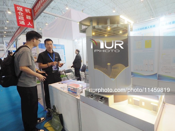 Visitors are viewing a model of the ''coal bunker cleaning robot'' at the 2024 Beijing International Coal Mining Technology and Equipment Ex...