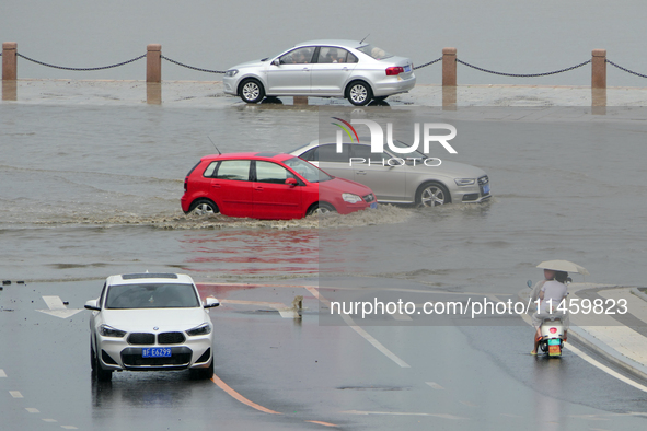 Vehicles are passing a waterlogged section of Binhai Middle Road in Yantai, China, on August 6, 2024. 