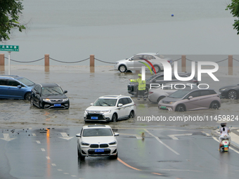 Vehicles are passing a waterlogged section of Binhai Middle Road in Yantai, China, on August 6, 2024. (