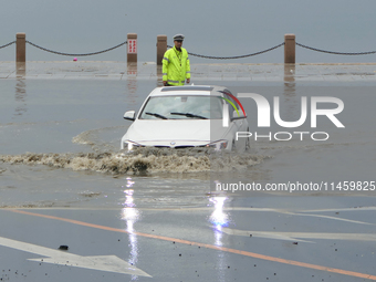 Vehicles are passing a waterlogged section of Binhai Middle Road in Yantai, China, on August 6, 2024. (