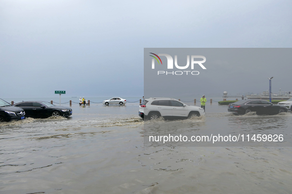 Vehicles are passing a waterlogged section of Binhai Middle Road in Yantai, China, on August 6, 2024. 