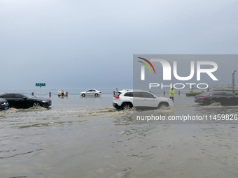 Vehicles are passing a waterlogged section of Binhai Middle Road in Yantai, China, on August 6, 2024. (