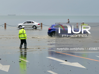 Vehicles are passing a waterlogged section of Binhai Middle Road in Yantai, China, on August 6, 2024. (