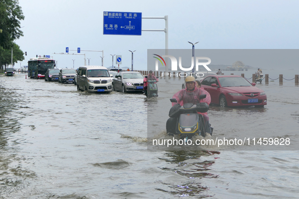 Vehicles are passing a waterlogged section of Binhai Middle Road in Yantai, China, on August 6, 2024. 