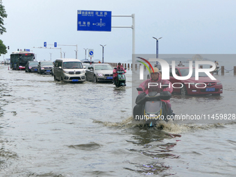 Vehicles are passing a waterlogged section of Binhai Middle Road in Yantai, China, on August 6, 2024. (