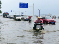 Vehicles are passing a waterlogged section of Binhai Middle Road in Yantai, China, on August 6, 2024. (