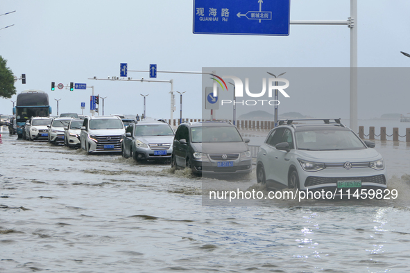 Vehicles are passing a waterlogged section of Binhai Middle Road in Yantai, China, on August 6, 2024. 