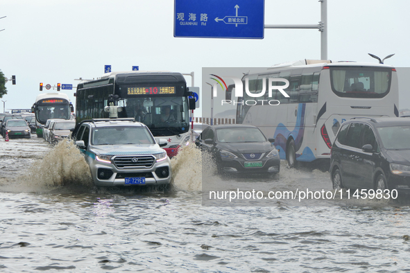 Vehicles are passing a waterlogged section of Binhai Middle Road in Yantai, China, on August 6, 2024. 