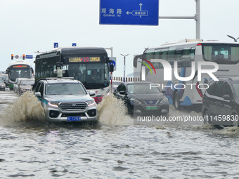 Vehicles are passing a waterlogged section of Binhai Middle Road in Yantai, China, on August 6, 2024. (