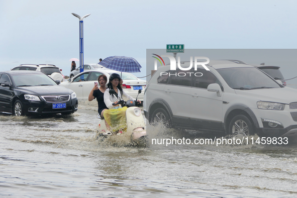 Vehicles are passing a waterlogged section of Binhai Middle Road in Yantai, China, on August 6, 2024. 