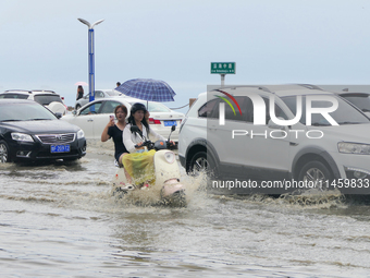 Vehicles are passing a waterlogged section of Binhai Middle Road in Yantai, China, on August 6, 2024. (