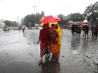 Women are walking on a road with an umbrella during heavy monsoon rain in Kolkata, India, on July 07, 2024. (