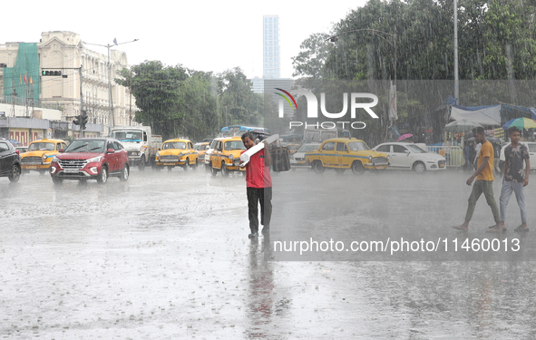 A man is crossing a busy road during heavy monsoon rain in Kolkata, India, on July 07, 2024. 