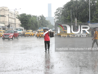 A man is crossing a busy road during heavy monsoon rain in Kolkata, India, on July 07, 2024. (