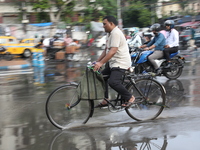 A man is riding his bicycle during heavy monsoon rain in Kolkata, India, on July 07, 2024. (