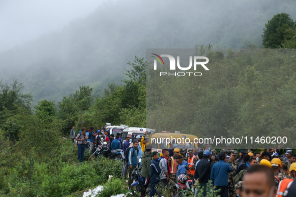 Nepali security forces are carrying the bodies of victims to the hearse from the site of the crashed Air Dynasty Helicopter in Nuwakot Distr...