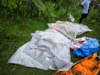 GRAPHIC WARNING: Dead bodies of the Chinese passengers on board the Air Dynasty Helicopter are being covered with plastic sheets near the cr...