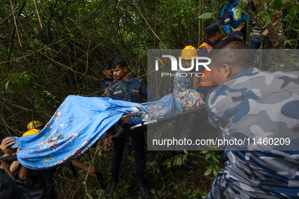 GRAPHIC WARNING: Members of the Nepal Armed Police Force and Nepal Police are retrieving a body from the crashed Air Dynasty Helicopter in N...