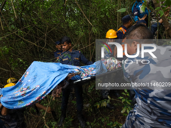 GRAPHIC WARNING: Members of the Nepal Armed Police Force and Nepal Police are retrieving a body from the crashed Air Dynasty Helicopter in N...