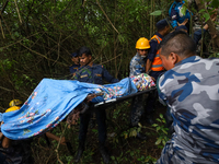 GRAPHIC WARNING: Members of the Nepal Armed Police Force and Nepal Police are retrieving a body from the crashed Air Dynasty Helicopter in N...