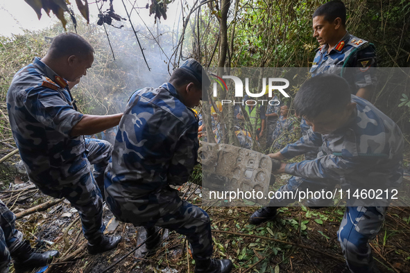 Rescuers and members of the search team from the Armed Police Force are taking out the wreckage of the Air Dynasty Helicopter that crashed i...