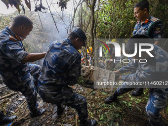 Rescuers and members of the search team from the Armed Police Force are taking out the wreckage of the Air Dynasty Helicopter that crashed i...