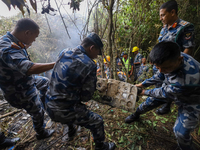 Rescuers and members of the search team from the Armed Police Force are taking out the wreckage of the Air Dynasty Helicopter that crashed i...