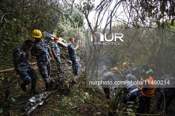 Members of the Nepal Armed Police Force and Nepal Police are searching the wreckage of the Air Dynasty Helicopter that crashed in Nuwakot Di...