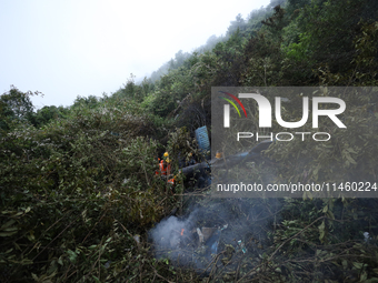 Members of the Nepal Armed Police Force and Nepal Police are searching the wreckage of the Air Dynasty Helicopter that crashed in Nuwakot Di...