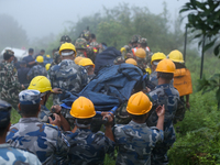 Nepali security forces are carrying the bodies of victims to the hearse from the site of the crashed Air Dynasty Helicopter in Nuwakot Distr...