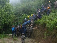 Nepali security forces are carrying the bodies of victims to the hearse from the site of the crashed Air Dynasty Helicopter in Nuwakot Distr...