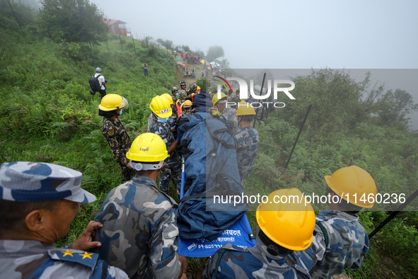 Nepali security forces are carrying the bodies of victims to the hearse from the site of the crashed Air Dynasty Helicopter in Nuwakot Distr...