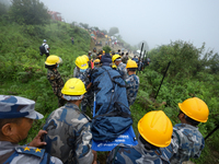 Nepali security forces are carrying the bodies of victims to the hearse from the site of the crashed Air Dynasty Helicopter in Nuwakot Distr...