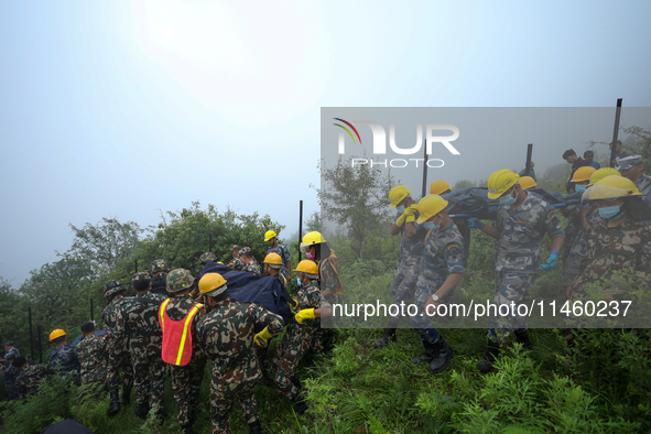 Nepali security forces are carrying the bodies of victims to the hearse from the site of the crashed Air Dynasty Helicopter in Nuwakot Distr...