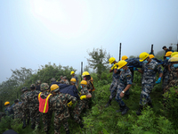 Nepali security forces are carrying the bodies of victims to the hearse from the site of the crashed Air Dynasty Helicopter in Nuwakot Distr...