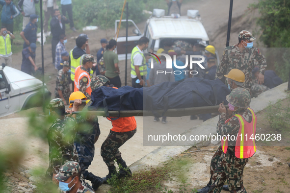 Nepali security forces are carrying the bodies of victims to the hearse from the site of the crashed Air Dynasty Helicopter in Nuwakot Distr...