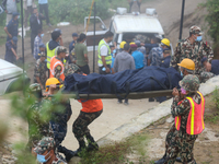 Nepali security forces are carrying the bodies of victims to the hearse from the site of the crashed Air Dynasty Helicopter in Nuwakot Distr...