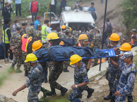 Nepali security forces are carrying the bodies of victims to the hearse from the site of the crashed Air Dynasty Helicopter in Nuwakot Distr...